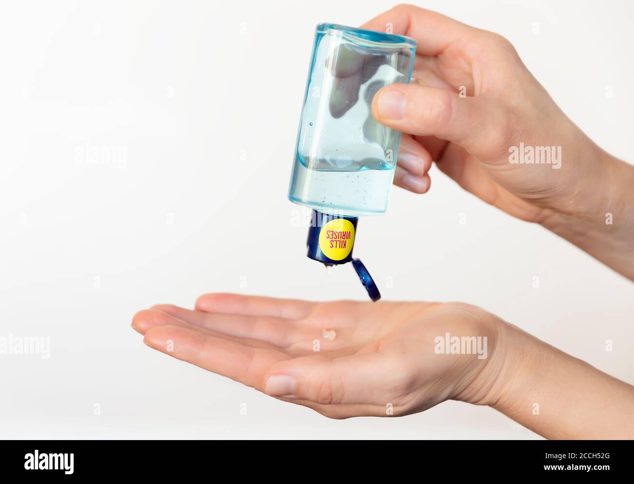 Una persona que sanea las manos con un desinfectante antibacteriano de una botella y previene la propagación de gérmenes, bacterias y virus de la corona. Foto de stock