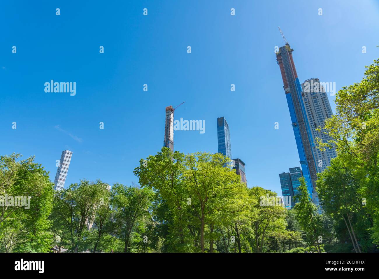 El rascacielos de Manhattan está detrás de árboles verdes frescos en el centro Parque Foto de stock