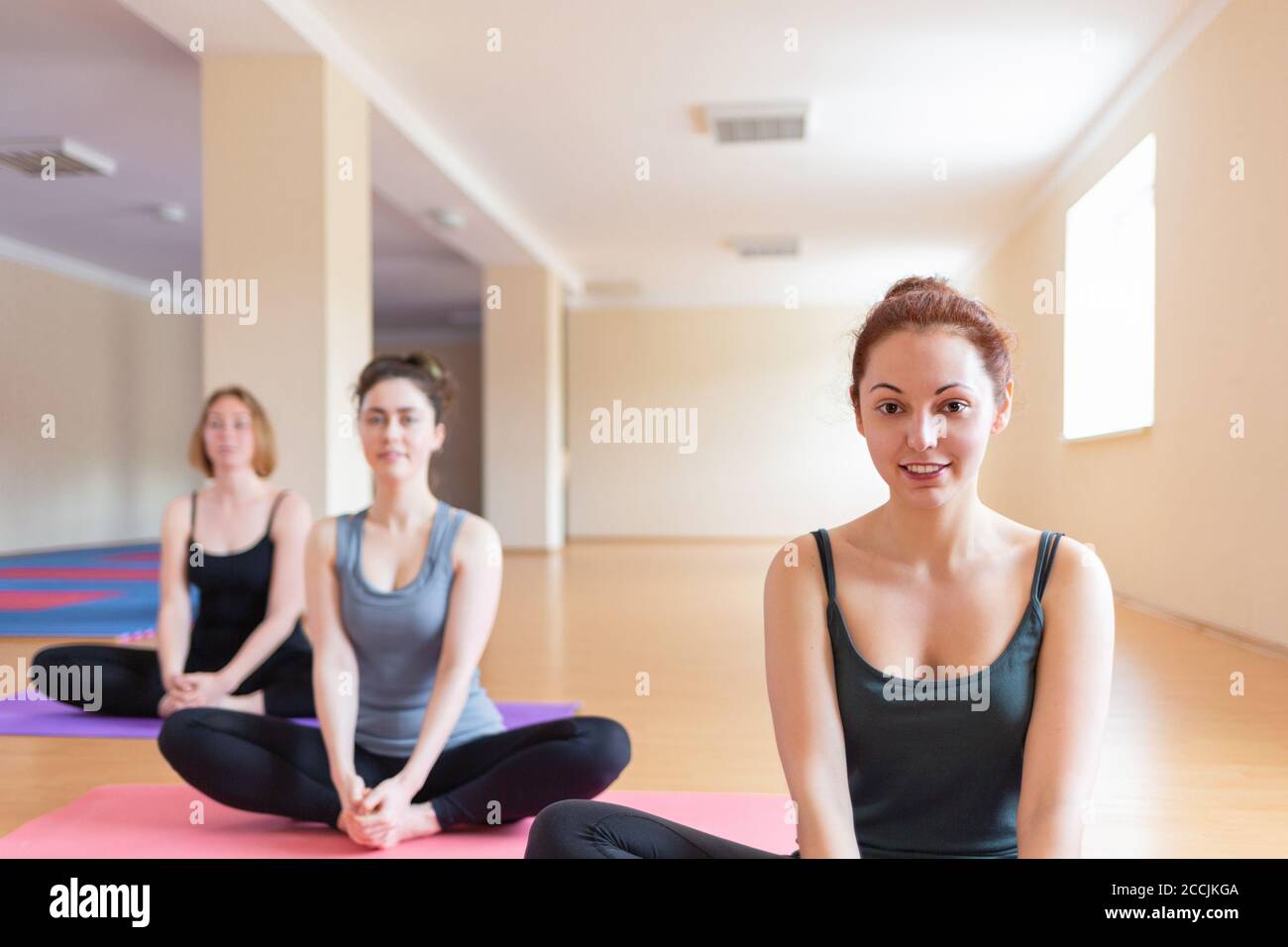 Las mujeres jóvenes hacen yoga en el aula. El concepto de estilo de vida deportivo, salud y equilibrio espiritual. Foto de stock