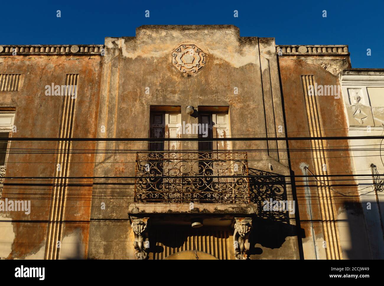 Fachada abandonada de casa colonial con estuco y balcón iluminado por el  sol, Mérida, Yucatán, México Fotografía de stock - Alamy