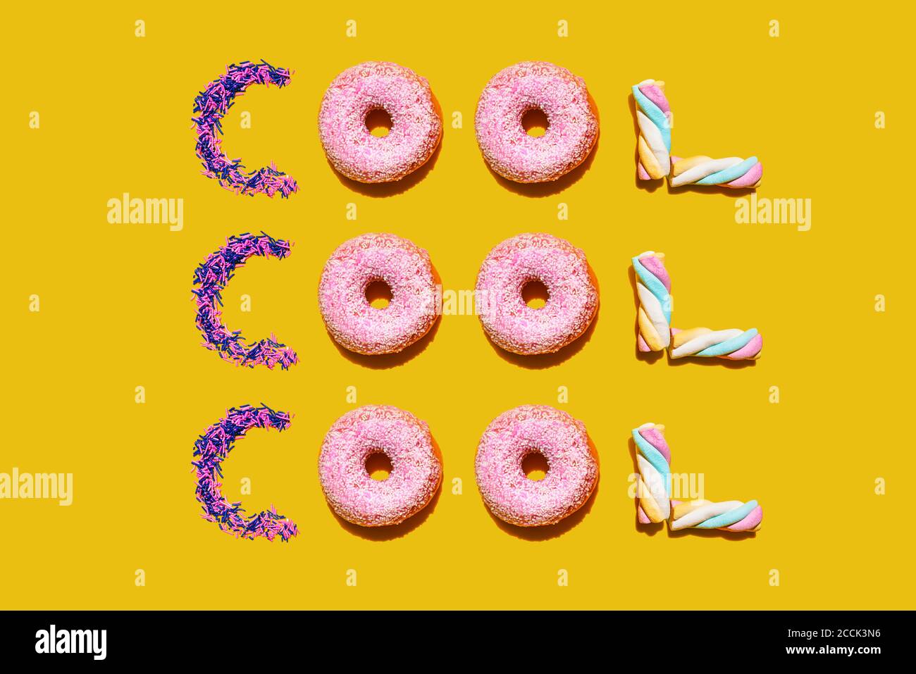Donuts, malvaviscos y azucar espolvorean dispuestos en una sola palabra repetida Foto de stock