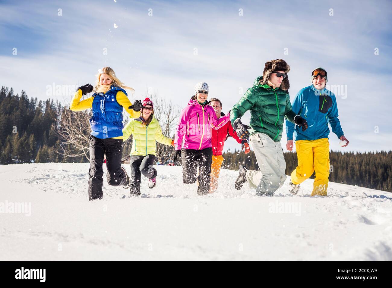 Grupo de amigos despreocupados corriendo y divirtiéndose en la nieve, Achenkirch, Austria Foto de stock