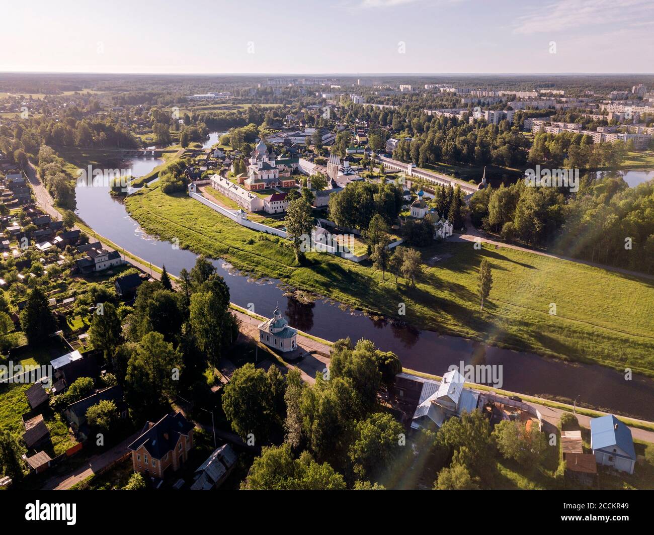 Rusia, Oblast de Leningrado, Tikhvin, Vista aérea del río Tikhvinka doblándose frente al monasterio de Tikhvin de la Dormición de la Madre de Dios Foto de stock