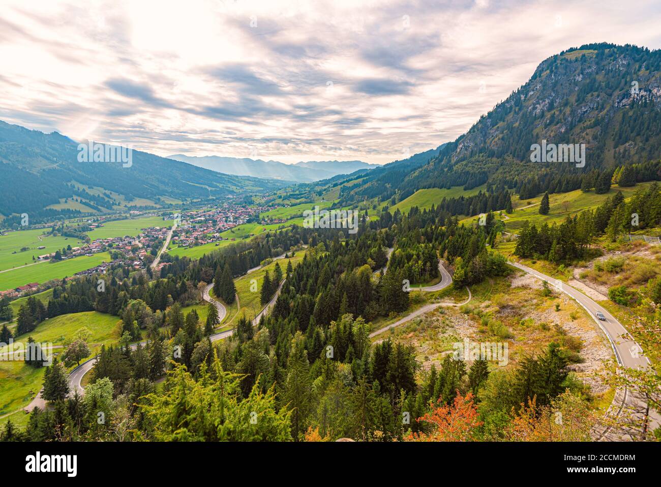 Coche en las montañas de Baviera, Alemania, Europa. Desplazamiento automático. Cielo nublado y miuntines en el fondo. Foto de stock
