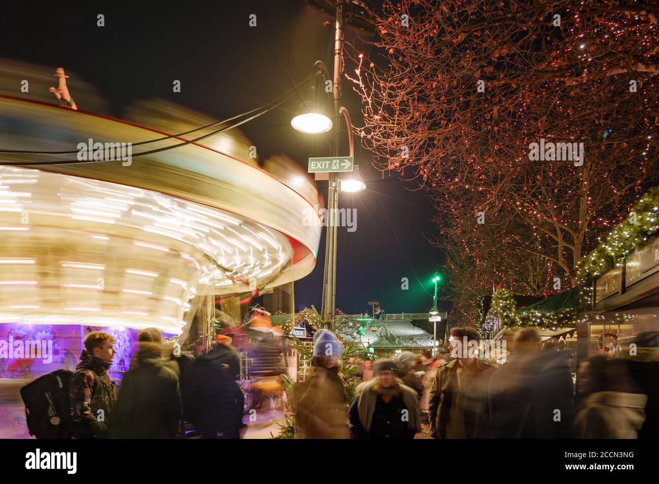 Multitud de personas, iluminar puestos y carrusel durante Weihnachtsmarkt, mercado de Navidad en Heumarkt, famosa plaza del mercado de Navidad en Colonia. Foto de stock