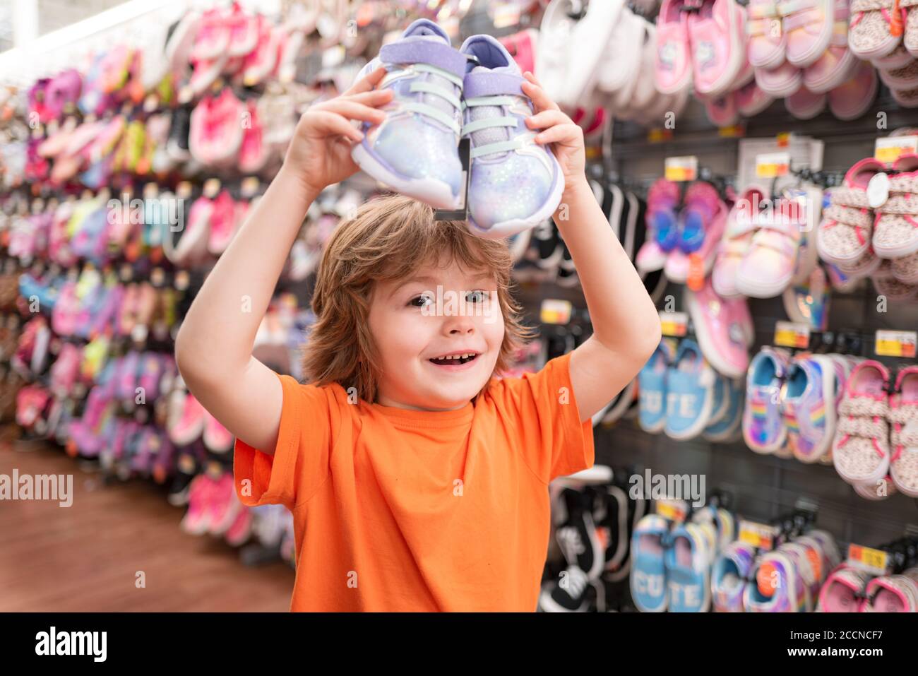 Los niños de la tienda de zapatos en supermercado, la elección de los niños en la tienda de zapatos. Tienda de zapatos para niños. Niño en tienda de zapatos supermercado.