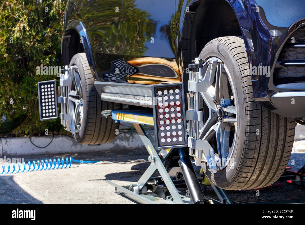 Equipo para alinear las ruedas de un coche sobre un soporte móvil en una estación de reparación. El se apoya en un soporte con sensores de rueda para la alineación de