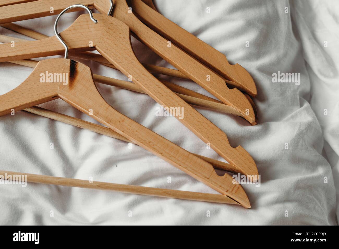 Muchas perchas de madera. Trempel sobre un fondo claro. Concepto de tienda, venta, diseño, percha vacía. Colocar para texto. Foto de stock