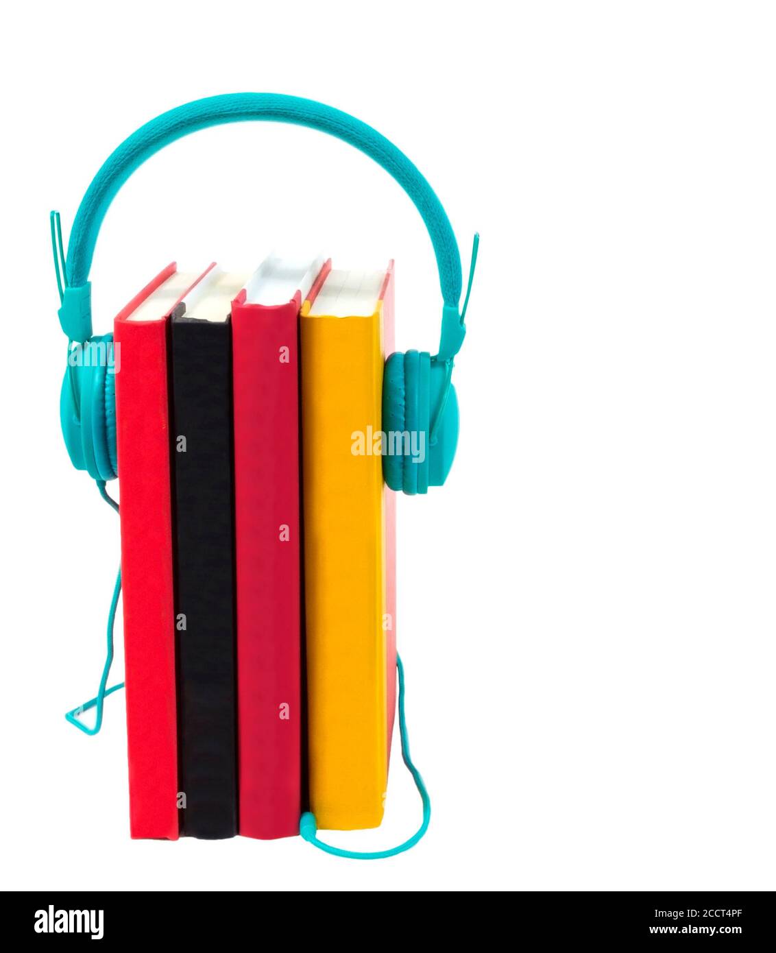 Disparo vertical de cuatro coloridos libros de pie en el final con un par de auriculares de color turquesa conectados en ellos. Aislado sobre blanco. Espacio de copia. Foto de stock