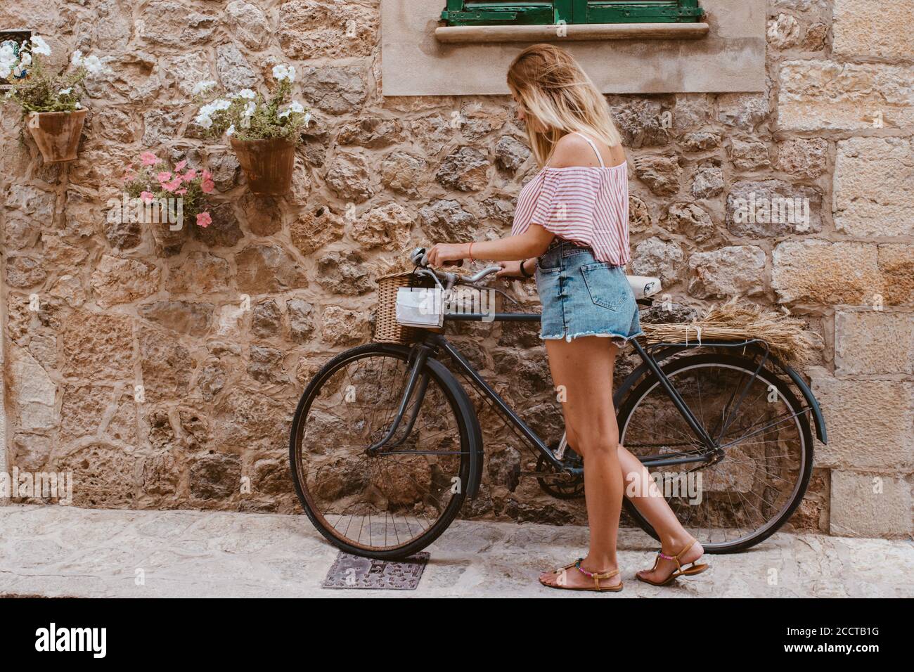 Mujer rubia elegir la bicicleta como el transporte en Mallorca Foto de stock