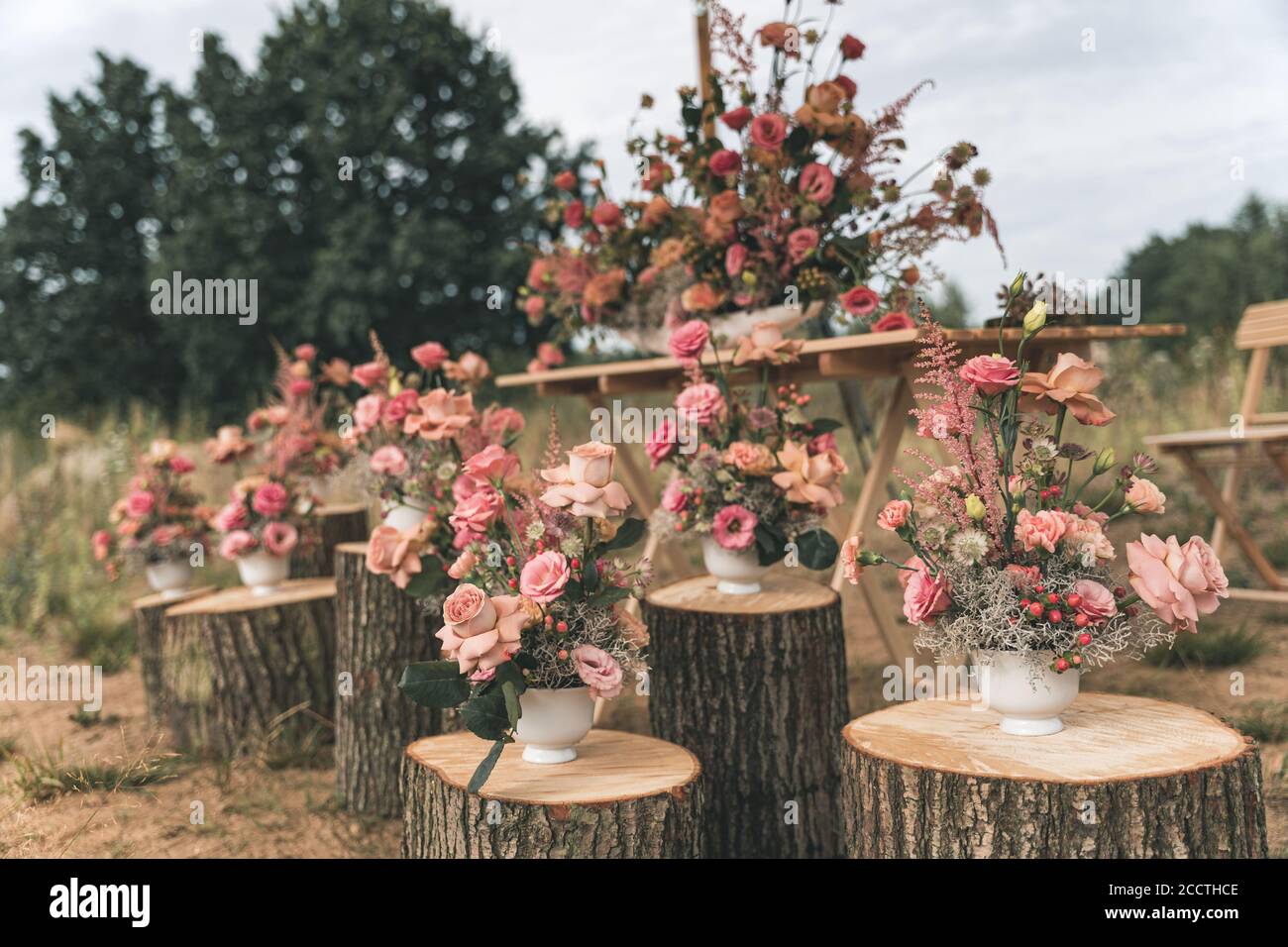 Arreglo de flores rosas en los troncos para una boda Foto de stock