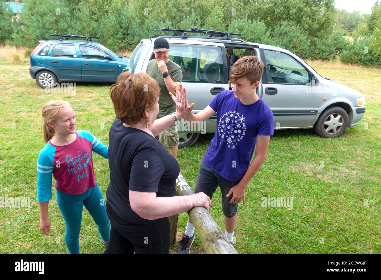 Abuela y nieto comparando el tamaño de los dedos con la nieta y el hijo observando durante un alto cinco Adiós. Zawady Gmina Rzeczyca Polonia Foto de stock