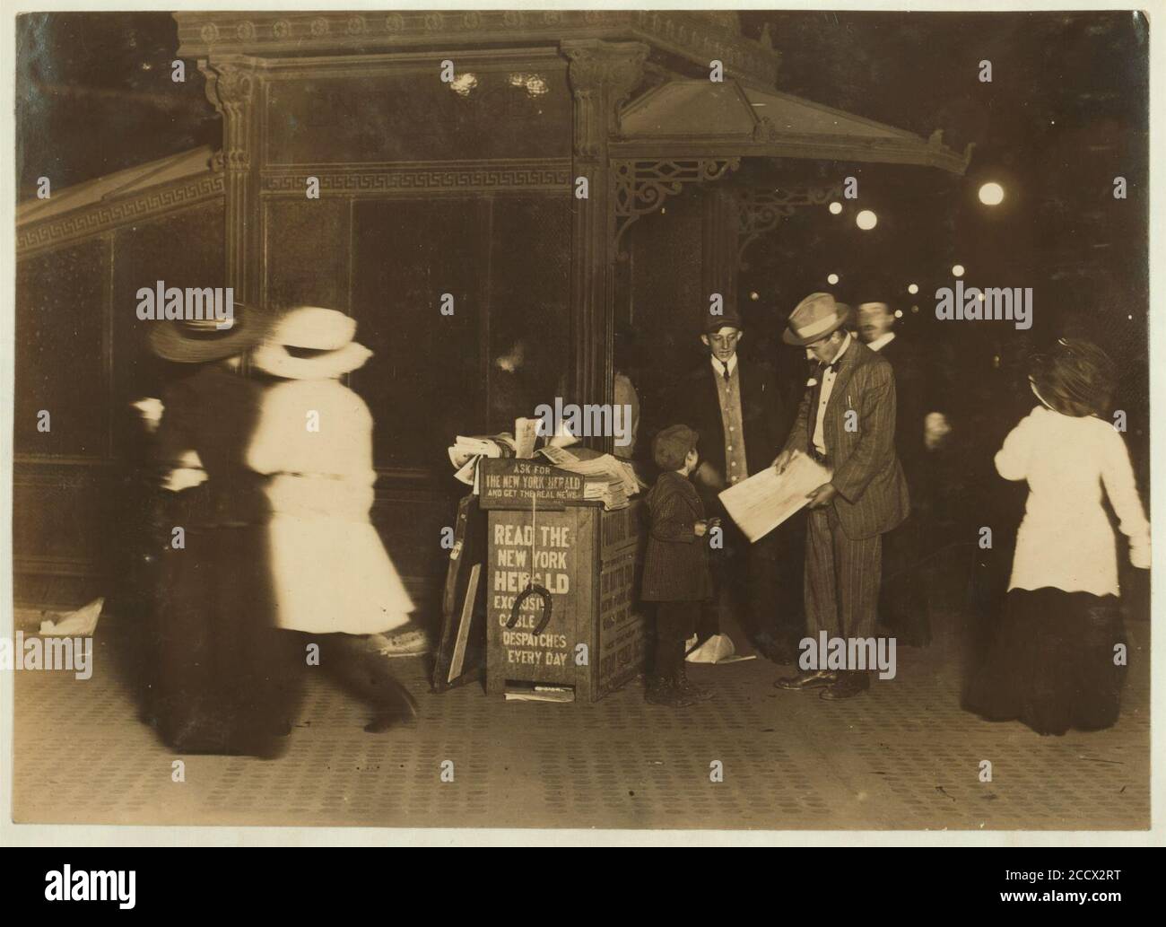 Jerald Schaitberger de 416 W. 57th St. N. Y. que ayuda a un niño mayor a vender papeles. Hasta las 10 P.M. en Columbus Circle. 7 años. 9-30 P.M., 8 de octubre de 1910) Foto de stock