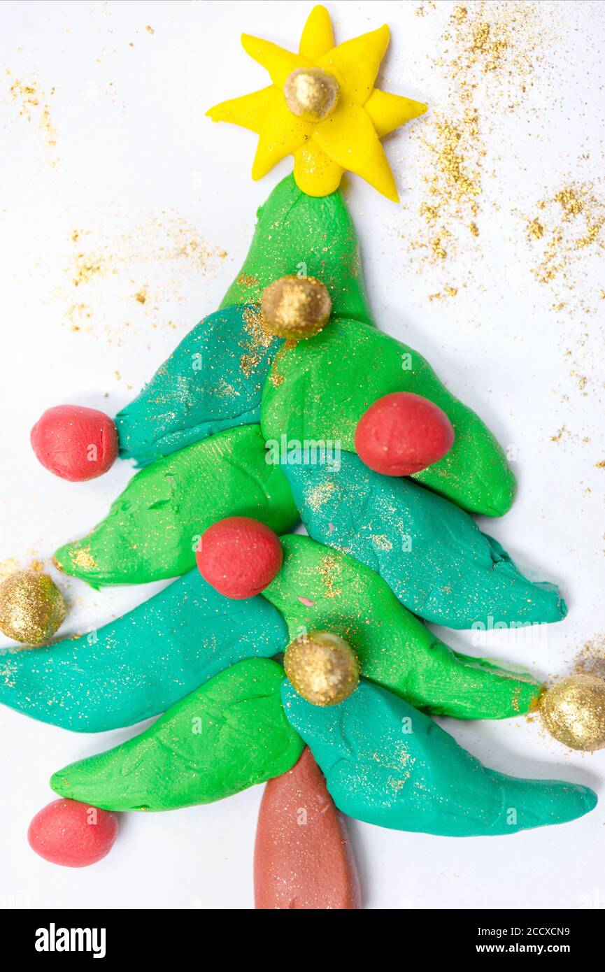 Árbol de Navidad plastilina con estrella. Oro y bola de Navidad roja. Obras de arte para niños. Foto de stock