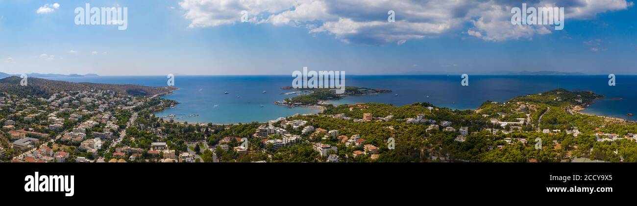 Atenas Grecia riviera panorama. Vista aérea de la costa de Vouliagmeni Lemos, distrito residencial de alta clase. Cielo azul nublado sobre agua de mar, sol Foto de stock