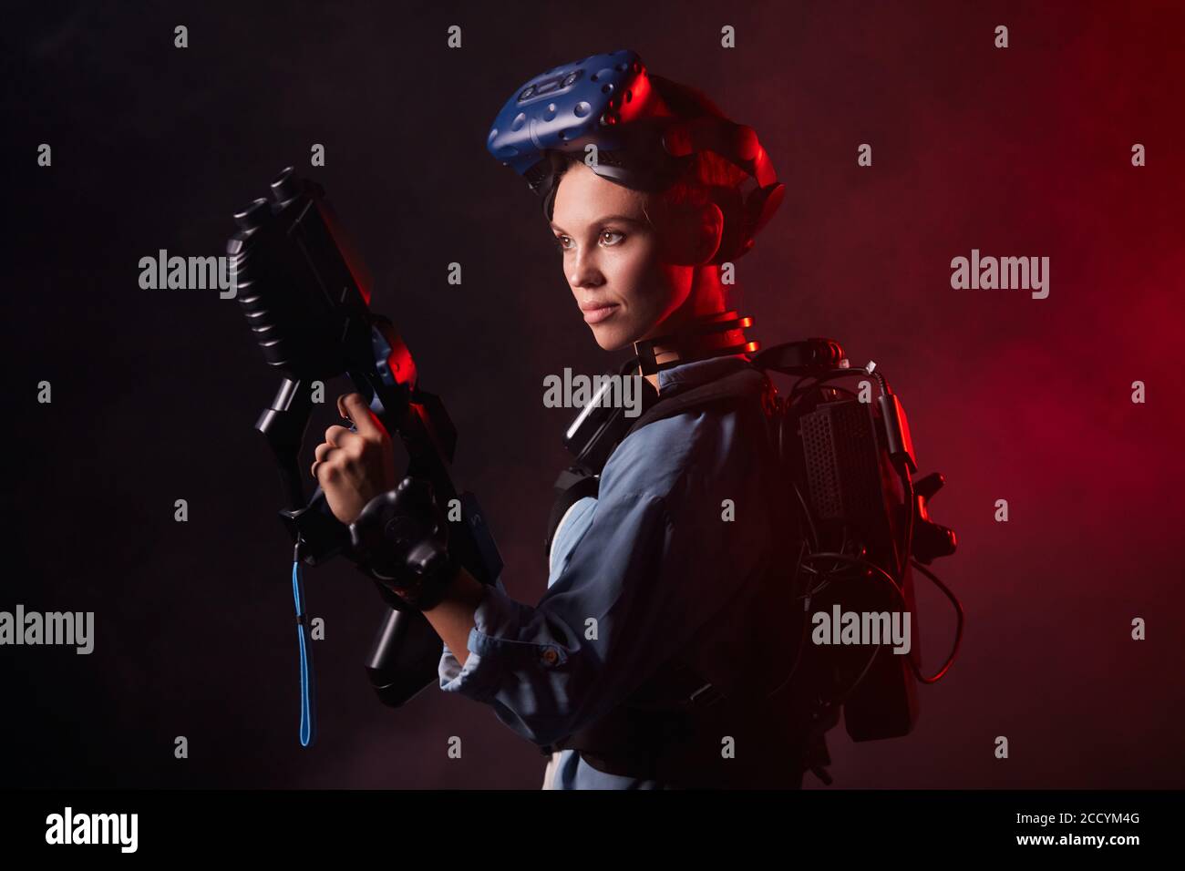 Retrato de la hembra amateur de juego de realidad virtual, pararse mirando  al lado en el espacio aislado, sala de juegos con neón rojo retroiluminado  Fotografía de stock - Alamy