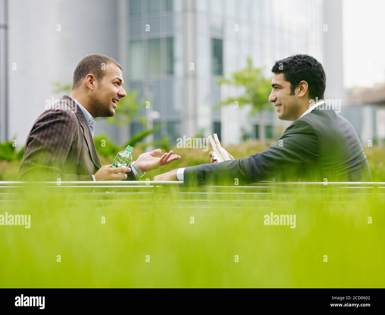 Dos hombres de negocios disfrutando del almuerzo comer Sandwich al aire libre Foto de stock