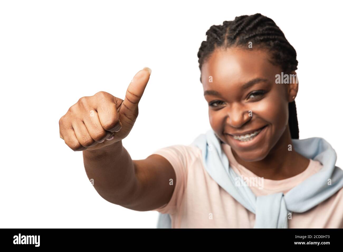 Chica del Milenio Africana gestuando Thumbs Arriba posando sobre fondo blanco Foto de stock