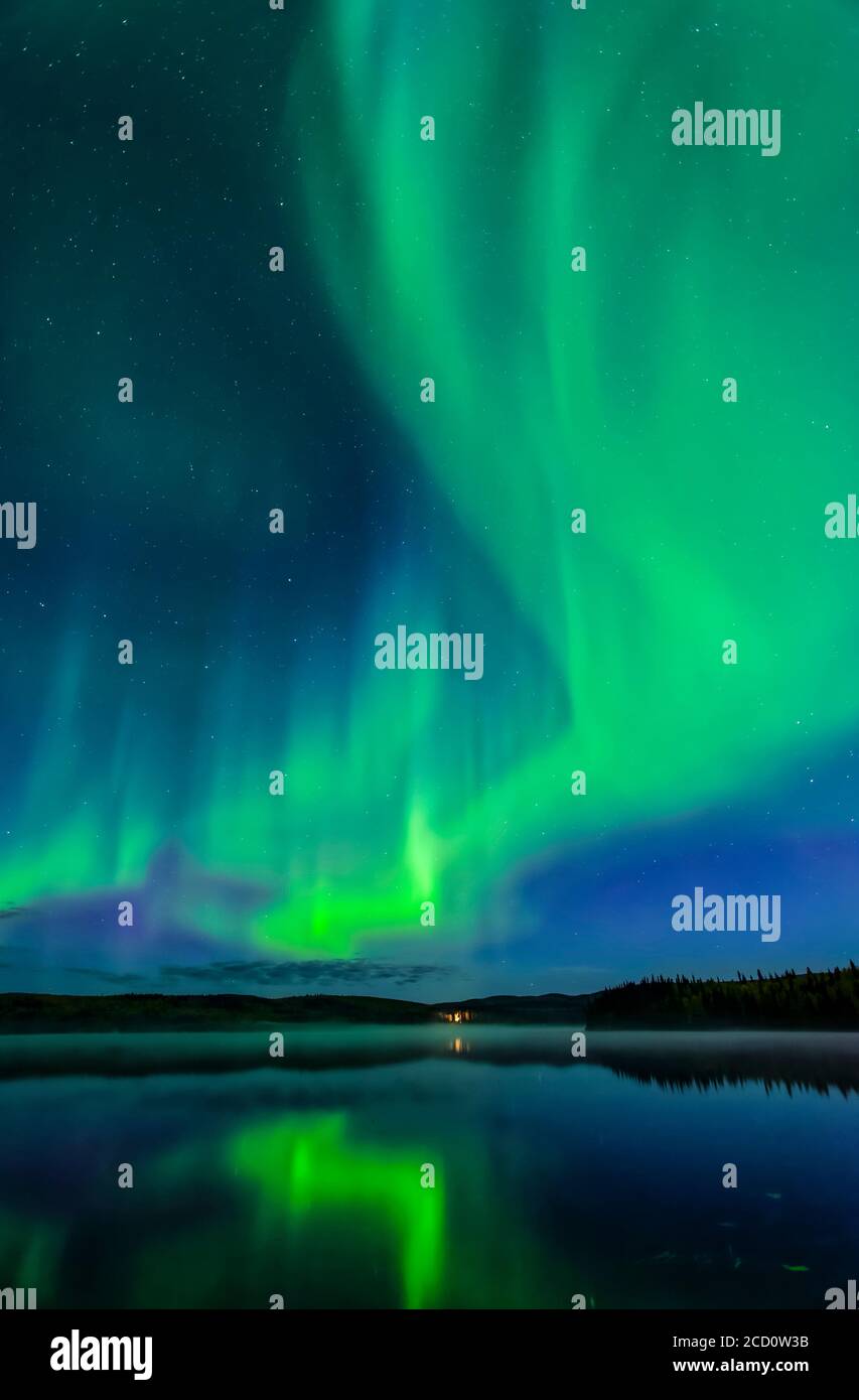 aurora verde brillante bailando como fuego sobre el Lago Birch con reflejos, Alaska interior en otoño; Fairbanks, Alaska, Estados Unidos de América Foto de stock