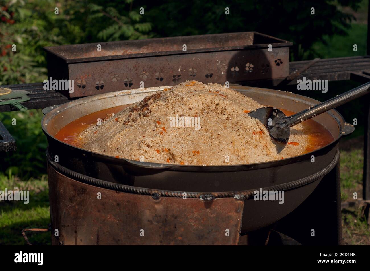 https://c8.alamy.com/compes/2cd1j4b/alimentacion-nacional-de-los-pueblos-del-este-pilaf-en-un-gran-caldero-arroz-y-cordero-cocidos-sobre-el-fuego-cocinar-comida-nacional-2cd1j4b.jpg