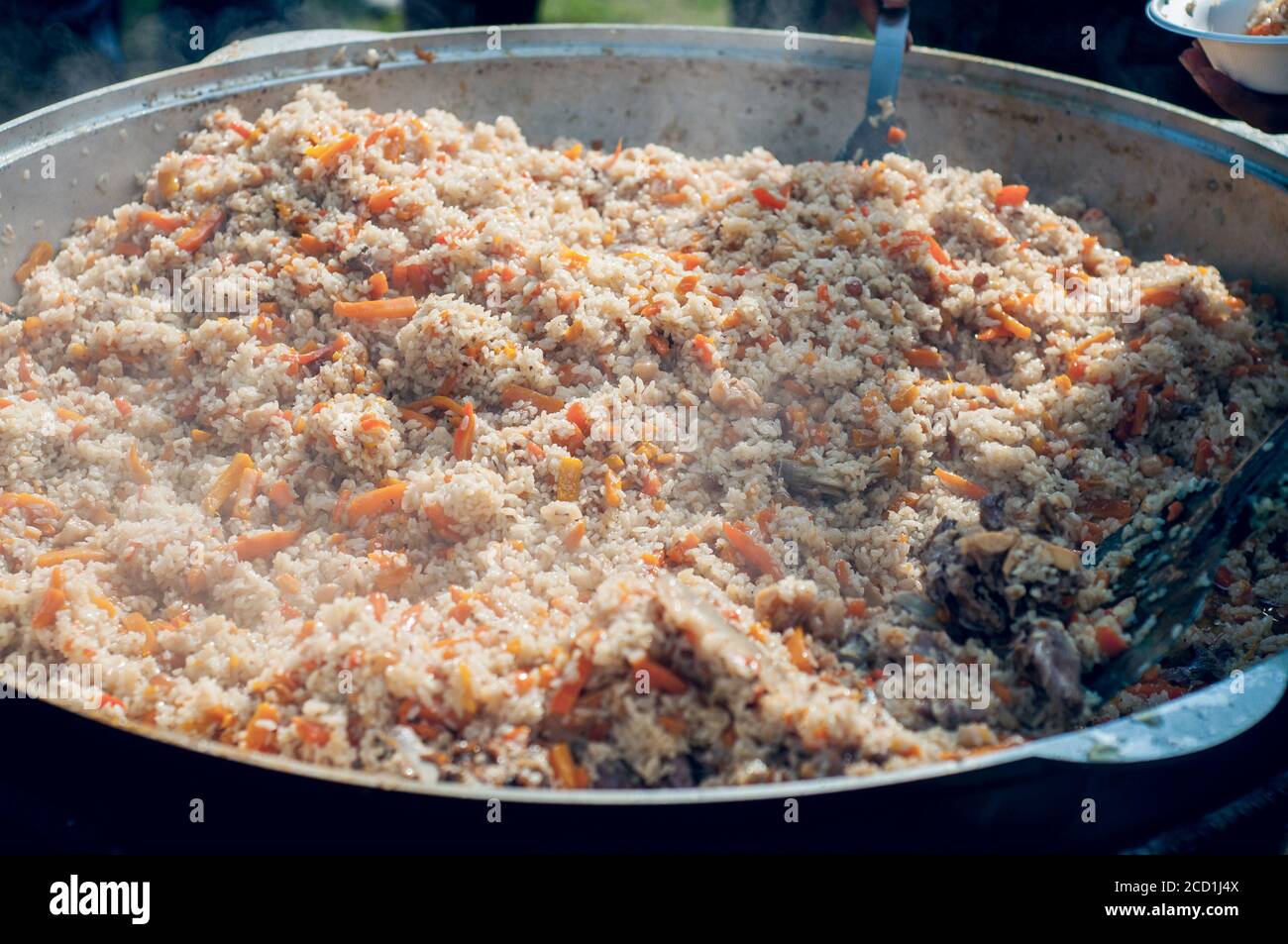 https://c8.alamy.com/compes/2cd1j4x/alimentacion-nacional-de-los-pueblos-del-este-pilaf-en-un-gran-caldero-arroz-y-cordero-cocidos-sobre-el-fuego-cocinar-comida-nacional-2cd1j4x.jpg