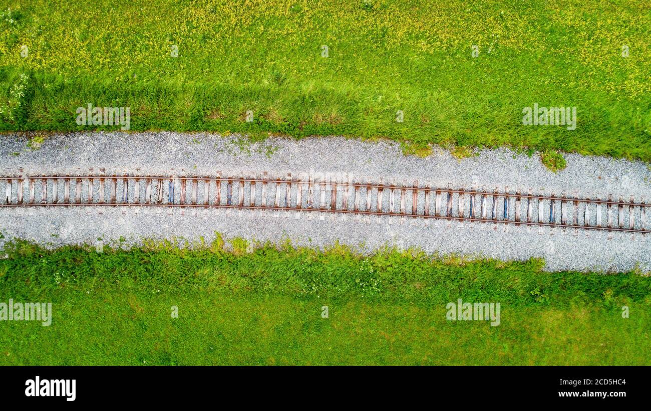 Vista aérea de una sola vía ferroviaria a través de campos verdes Foto de stock