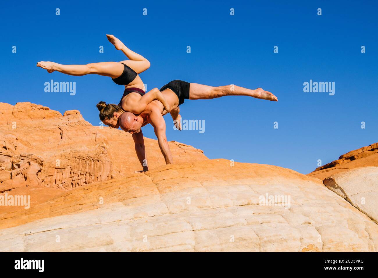 Pareja de gimnastas que equilibran en el desierto, Parque Estatal, Overton, Nevada, Estados Unidos Foto de stock
