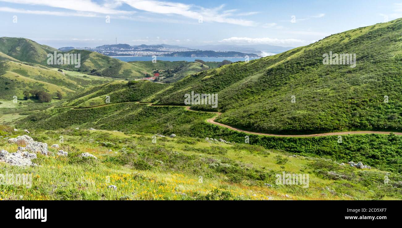 Paseo de primavera - el sendero Miwok conduce por un valle, con el Golden Gate y San Francisco en la distancia. Marin Headlands, California, Estados Unidos Foto de stock