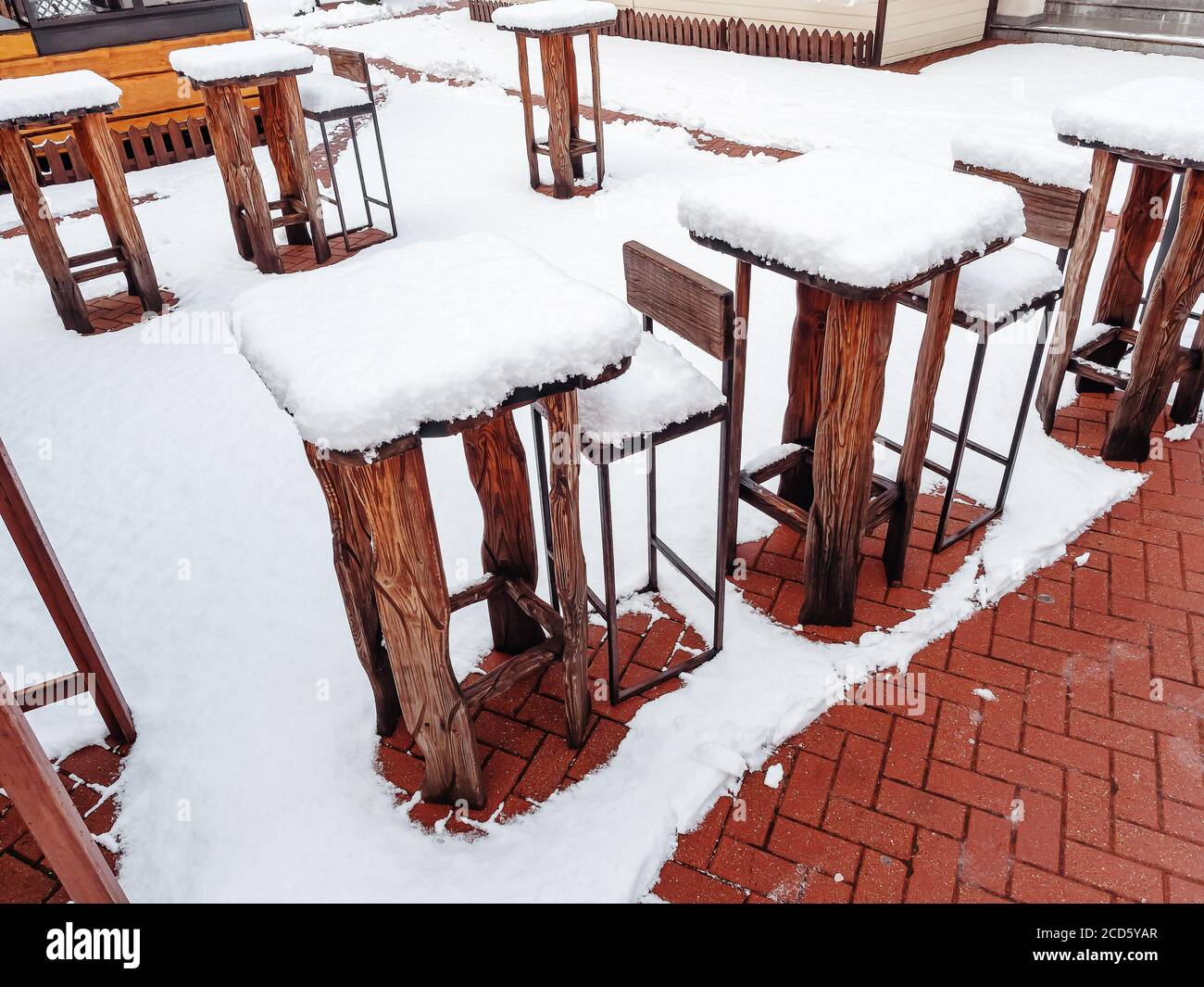 Mesas altas de madera y taburetes de bar de una cafetería al aire libre  manténgase en fila en invierno cubierto de nieve Fotografía de stock - Alamy