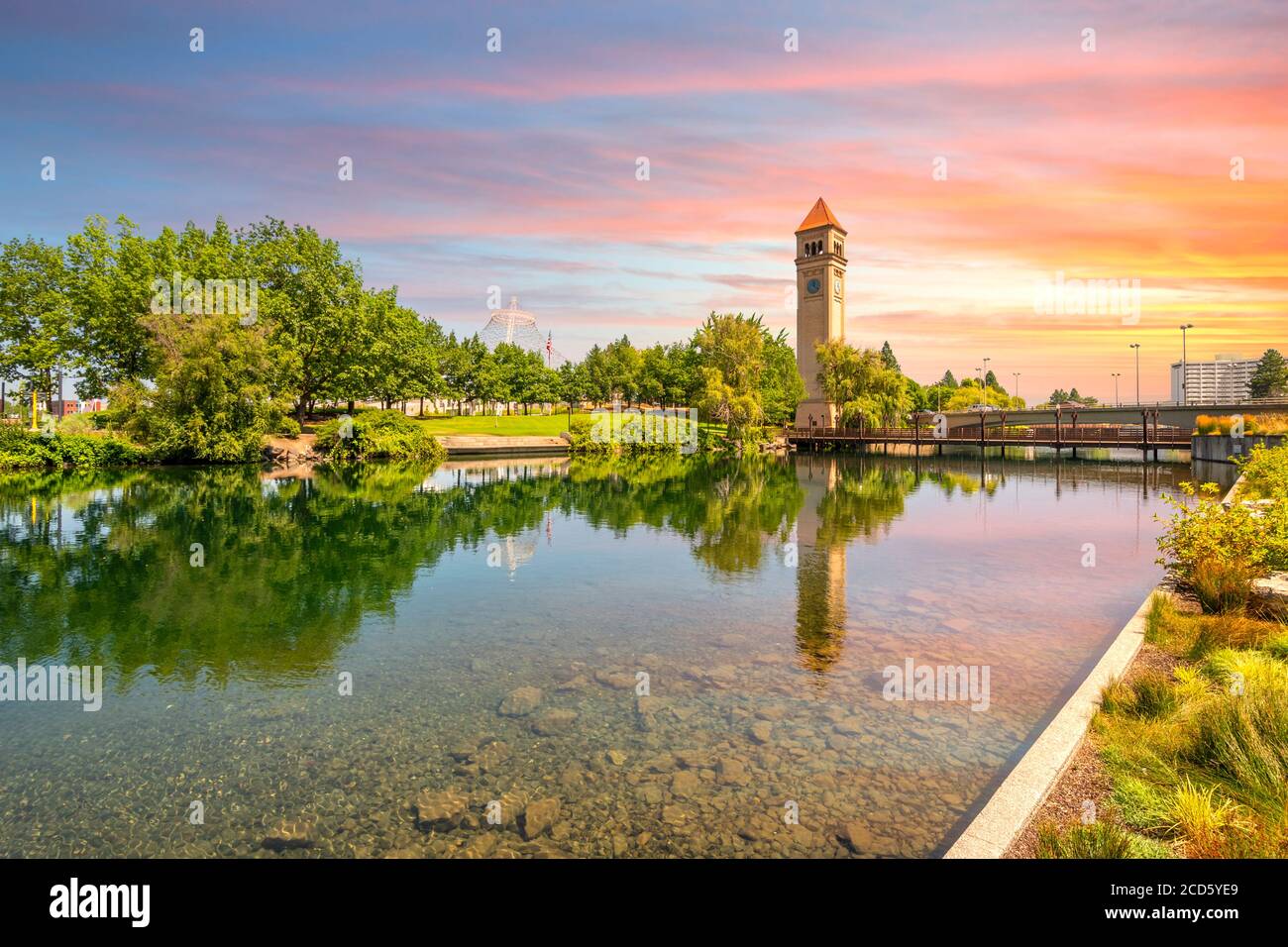 La torre del reloj de Spokane y el pabellón a lo largo del río en Riverfront Park, en el centro de Washington, bajo una colorida puesta de sol en Spokane, Washington, Estados Unidos Foto de stock