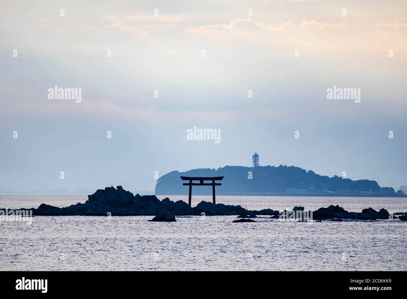 Rayo de luz sobre el mar con la vista de torii puerta y faro en la distancia Foto de stock