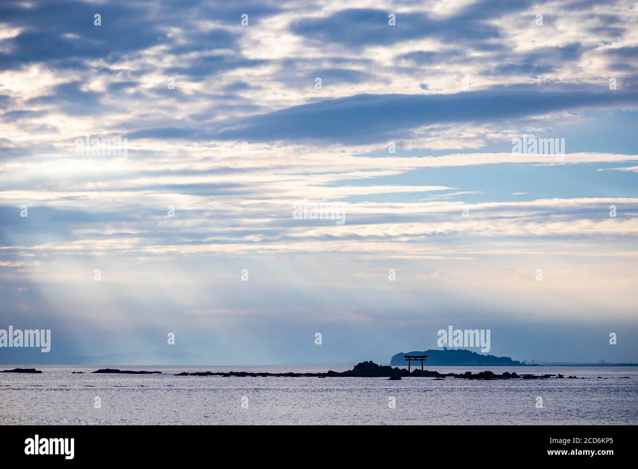 Rayo de luz sobre el mar con la vista de torii puerta y faro en la distancia Foto de stock