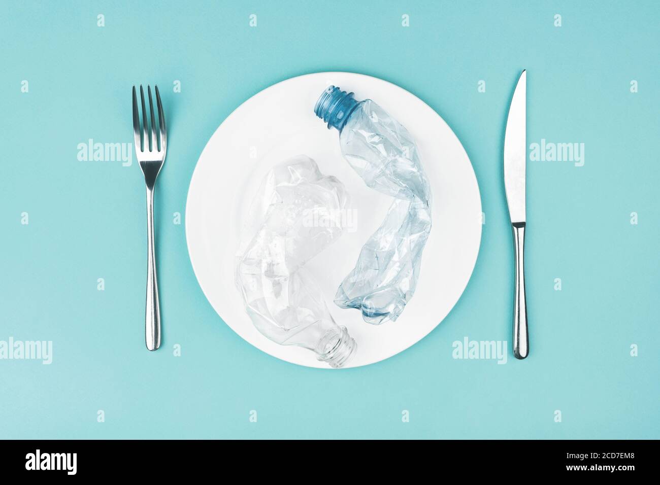 Plato con botellas de plástico sobre fondo azul. Foto de stock