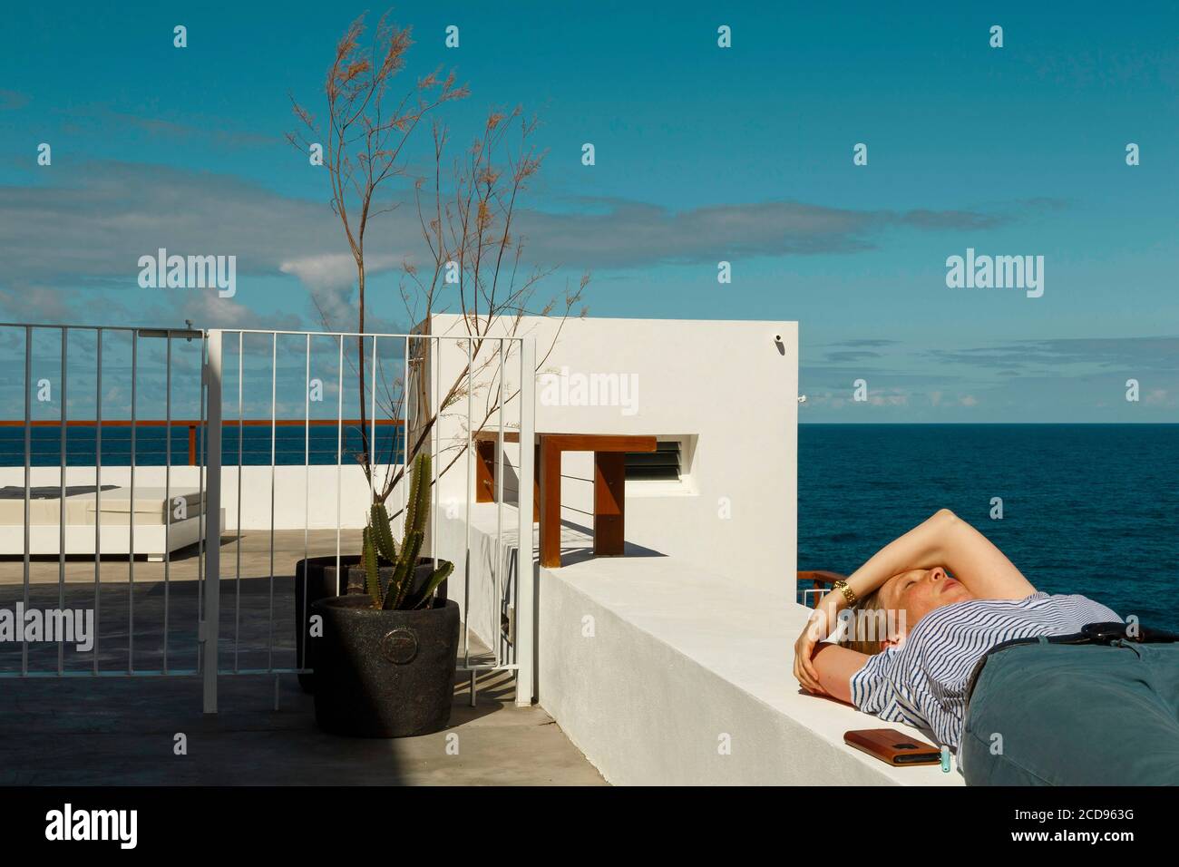 España, Islas Canarias, la Palma, joven descansando en el borde de una terraza junto al mar Foto de stock