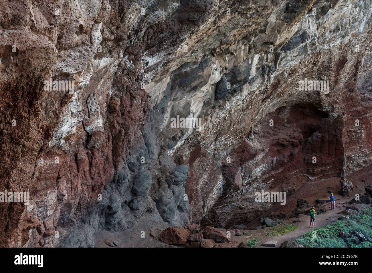 España, Islas Canarias, la Palma, los turistas en una ruta de senderismo bajo una bóveda de rocas volcánicas en la costa Foto de stock