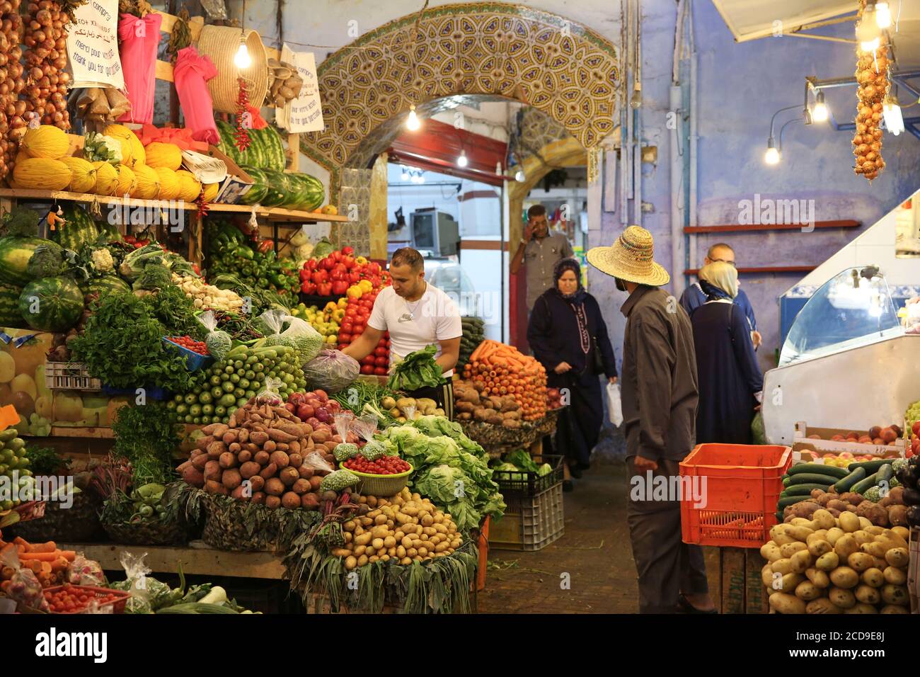 Marruecos, Tánger región de Tetuán, Tánger, Moroccanos compras frente a un puesto de frutas y verduras en el zoco Foto de stock