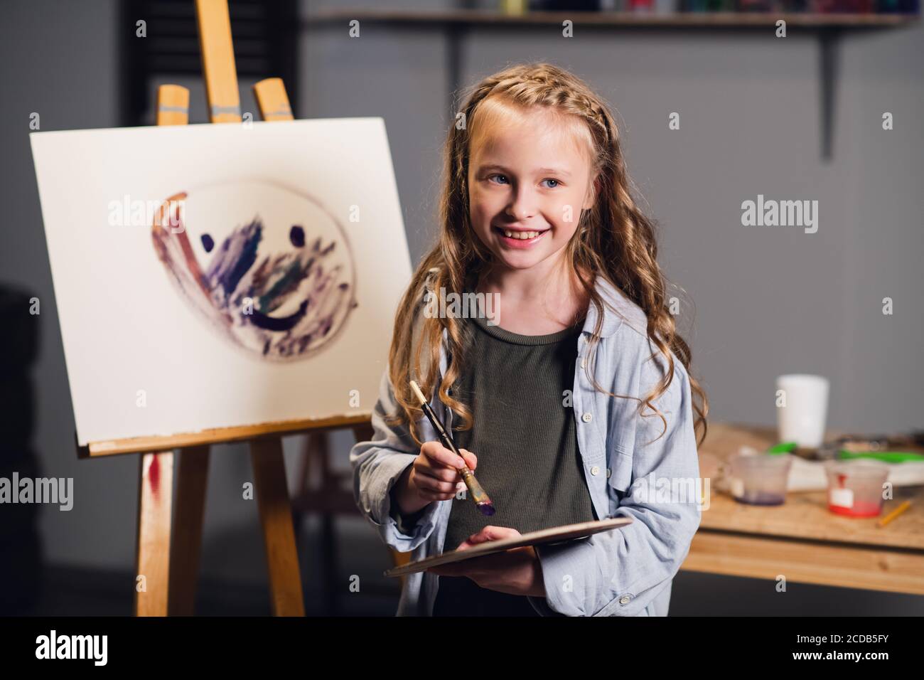 Primera lección en la escuela de arte, una niña aprende a dibujar y hace su  primera pintura al óleo sobre lienzo Fotografía de stock - Alamy