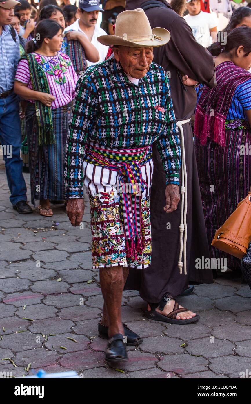 Un hombre maya tzutujil vestido tradicional, incluyendo pantalones a rayas  y bordados hasta la rodilla, en el mercado abierto de Santiago Atitlán,  Guatemala Fotografía de stock - Alamy