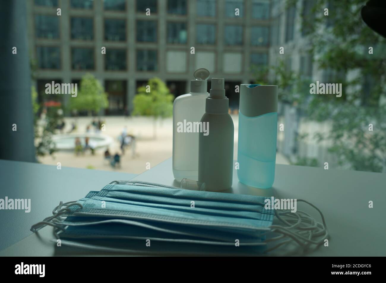 Varios desinfectantes de manos con varias máscaras faciales en la oficina como nueva norma para que los empleados cumplan con las normas de higiene y distanciamiento social para la prevención. Foto de stock