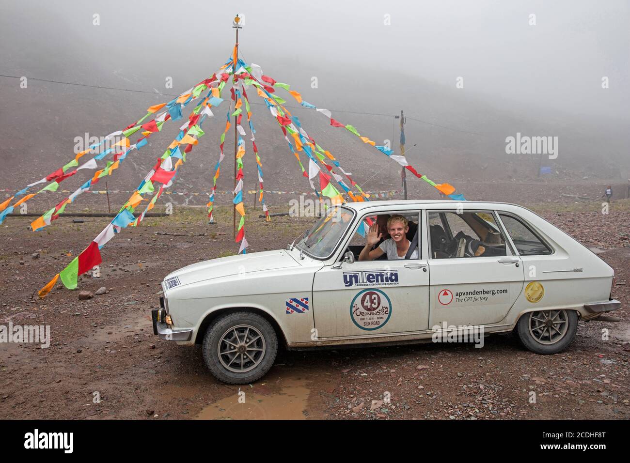 Paso de montaña chino del Himalaya con banderas de oración tibetanas y clásico concursante Renault, China Foto de stock