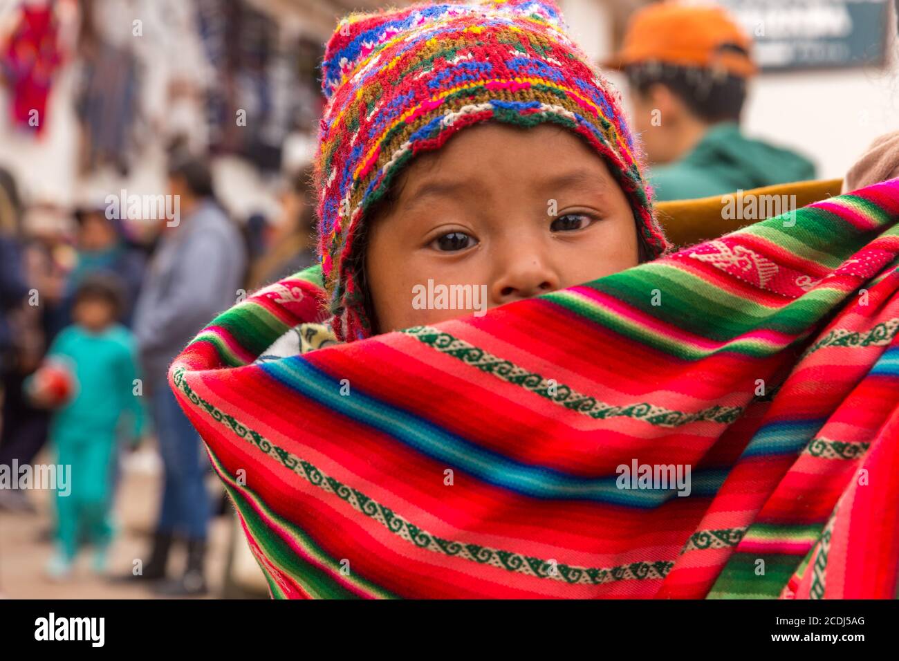 Chinchero, Perú - 05 de octubre de 2018: Mujer nativa vestida con ropa  tradicional y colorida camina en el mercado local con su bebé en la espalda  Fotografía de stock - Alamy