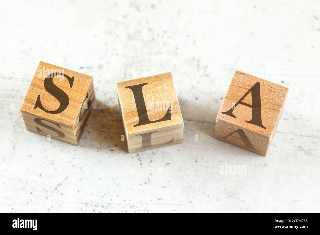 Tres cubos de madera con letras SLA (siglas en inglés de Service Level Agreement) en pizarra blanca. Foto de stock