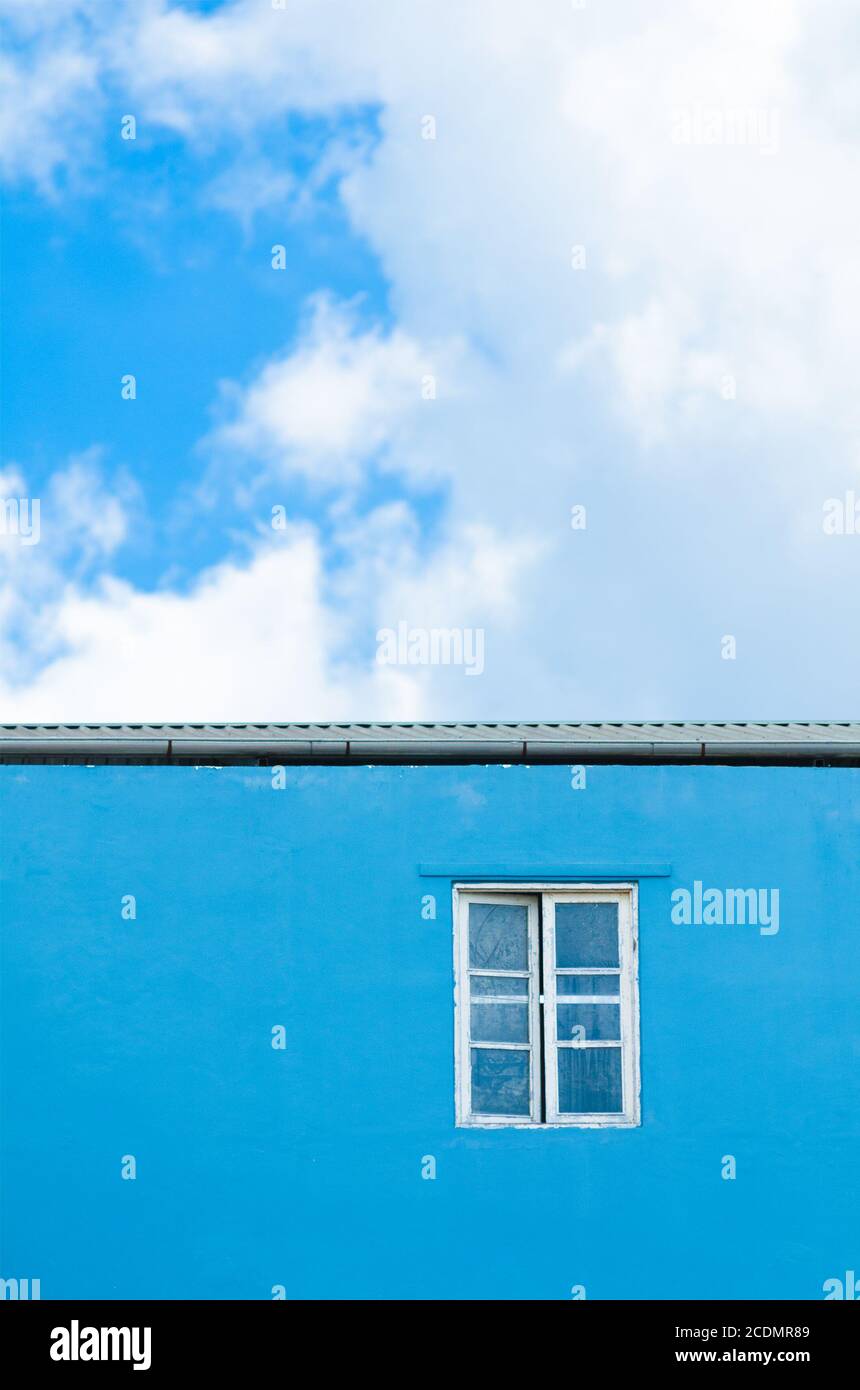 ventana en pared azul Foto de stock