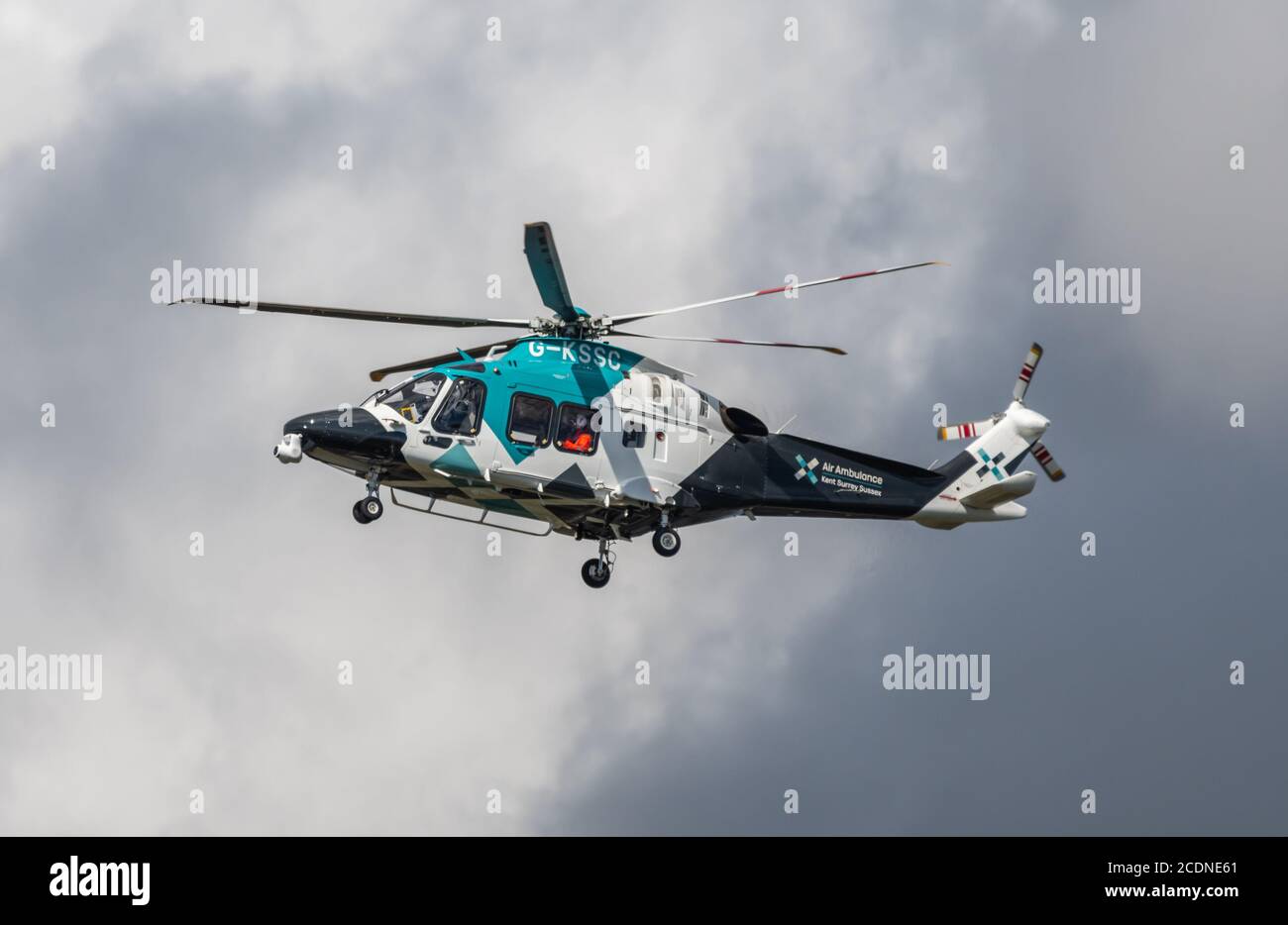 Ambulancia Aérea Helimed para Kent, Surrey & Sussex, un helicóptero médico, G-KSSC, AgustaWestland AW169, volando en cielos grises tormentosos en el Reino Unido. Foto de stock