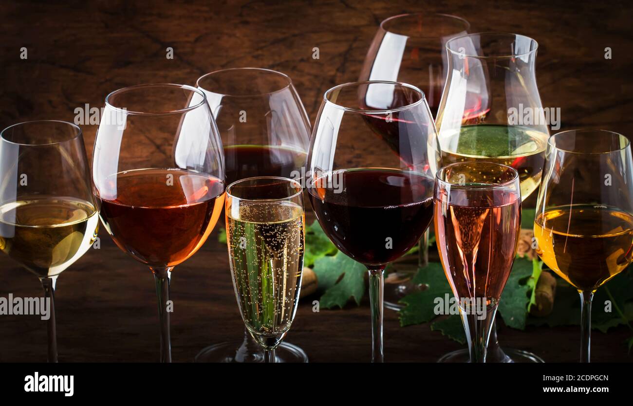 Concepto de cata de vinos, vinos sin gas y sin gas. Vino tinto, blanco,  rosa y champán en copas de vino sobre fondo de mesa de madera vintage  Fotografía de stock -