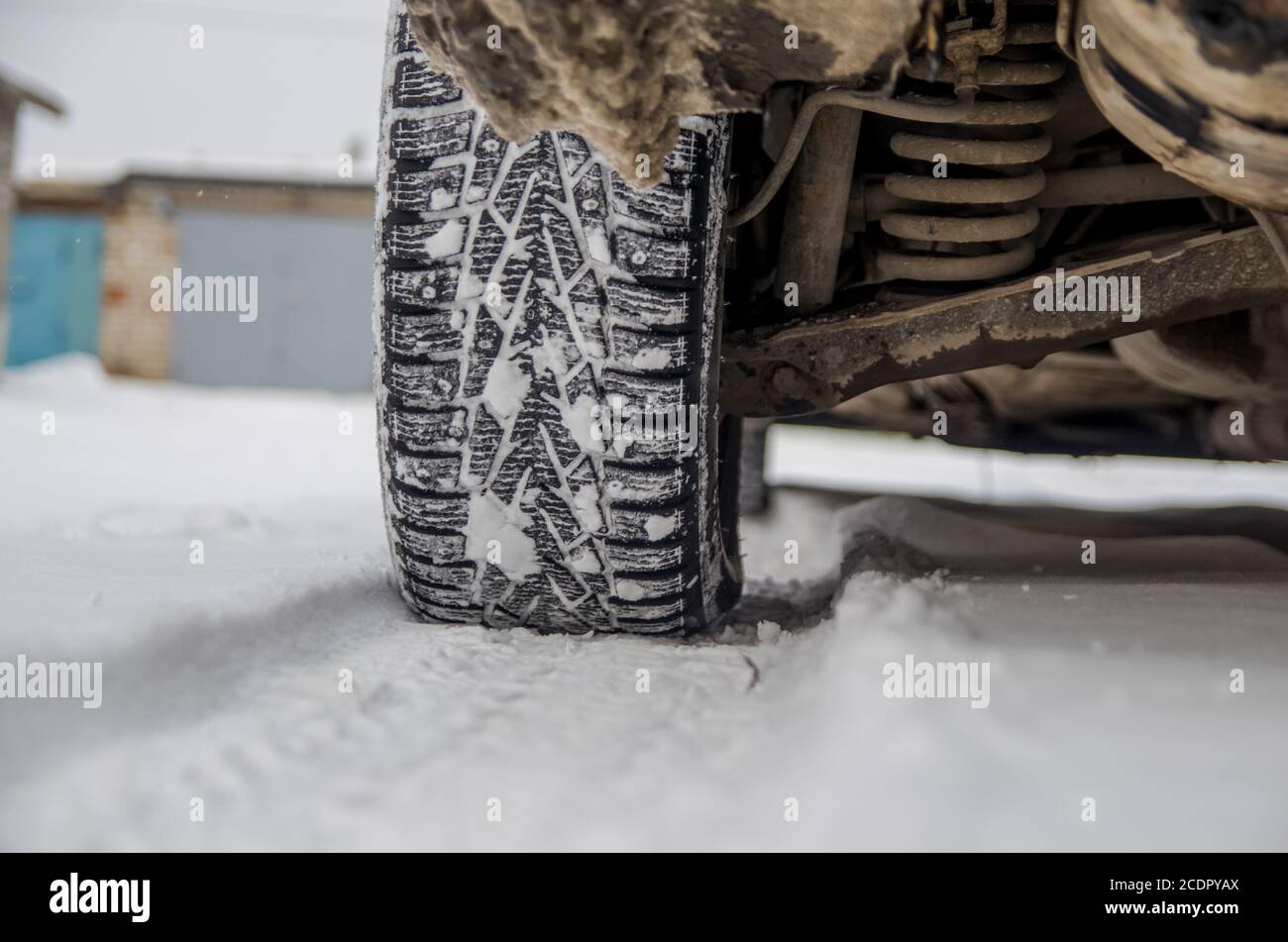 El neumático de coche en la nieve de cerca. Alquiler de pistas en la nieve. Los rastros de los en la Los neumáticos de invierno. Neumáticos invierno cubierto con