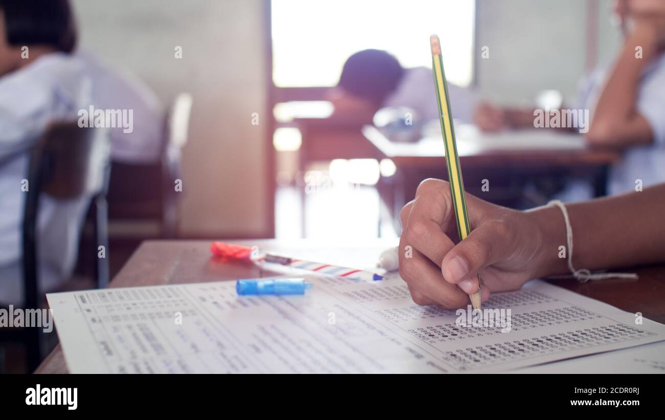 Mano de los estudiantes escribiendo y tomando el examen con el estrés en estilo aula.16:9 Foto de stock