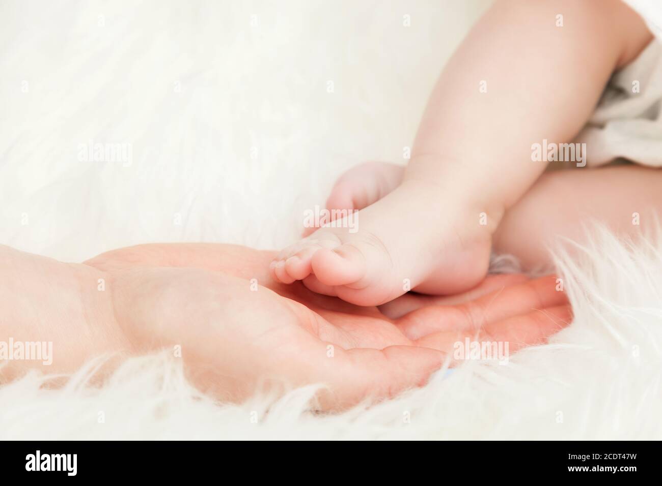 Pie del bebé recién nacido en la mano de la madre#39;s. Cuidado de niños, amor, protección Foto de stock