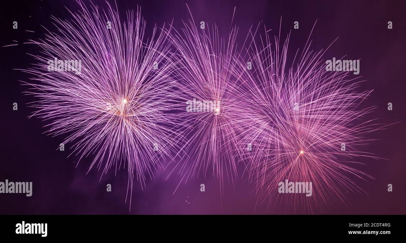 Espectaculares fuegos artificiales iluminan el cielo. Celebración de año Nuevo. Panorama Foto de stock