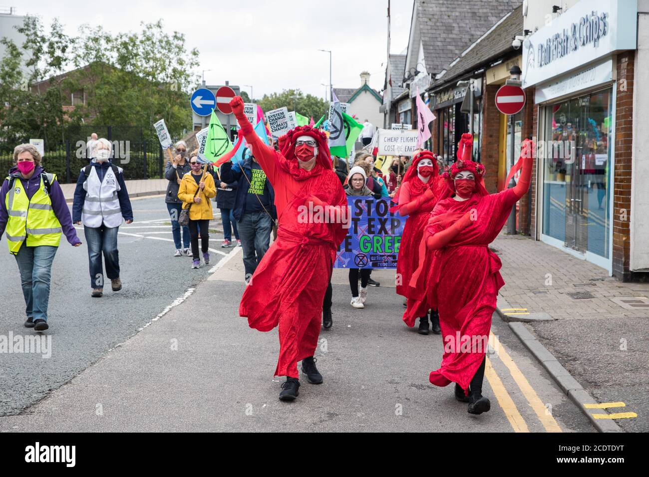 Bishop's Stortford, Reino Unido. 29 de agosto de 2020. Miembros de la Brigada Rebelda Roja se unen a otros activistas del clima de la Rebelión de extinción en una protesta contra la expansión del aeropuerto de Stansted. Los activistas piden al Manchester Airports Group que retire su apelación, para la cual el Consejo de Distrito de Uttlesford rechazó previamente la autorización de planificación, para poder ampliar el aeropuerto de Stansted de un máximo de 35 millones a 43 millones de pasajeros al año, Además, pide al Gobierno que detenga toda ampliación de los aeropuertos a fin de mantener sus compromisos en virtud del Acuerdo de París. Crédito: Mark Ke Foto de stock